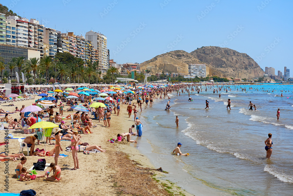 Tourists sunbathing on a Postiguet Beach of Alicante city. Spain