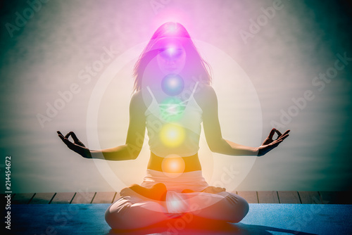 Foto Young woman in yoga meditation with seven chakras and Yin Yang symbols