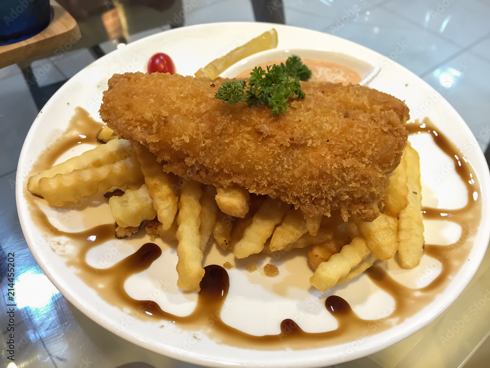 Fried fish steak with chips and black sauce