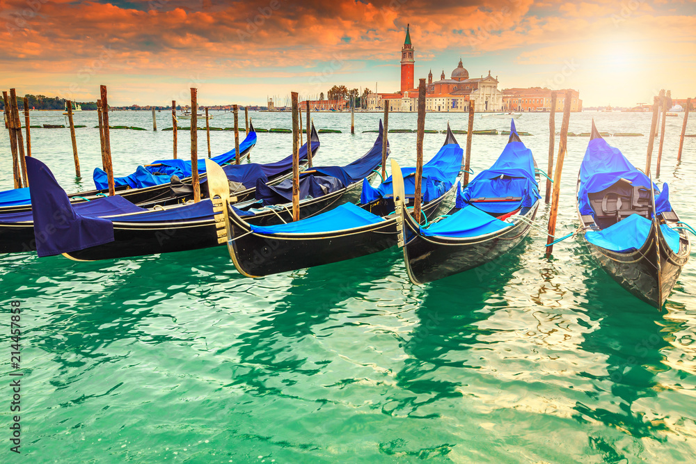 Wonderful colorful sunset with gondolas harbor in Venice, Italy, Europe