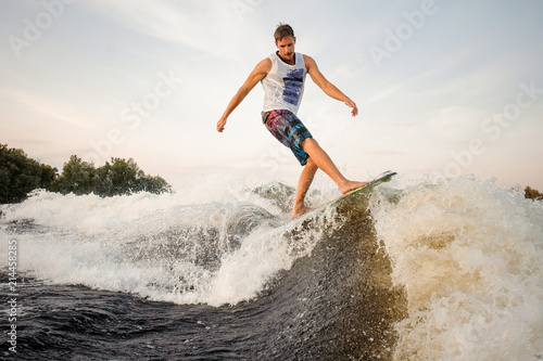 Active man riding on the wakeboard on the lake © fesenko