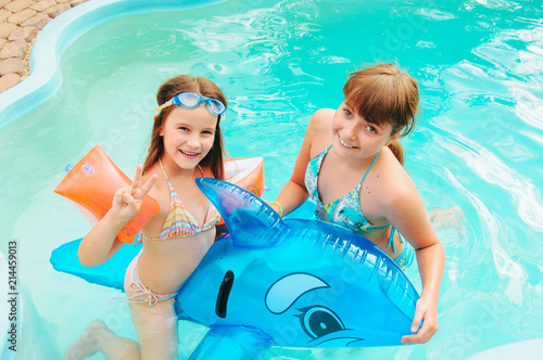 Wallpaper Mural little girls is swimming in the pool by a summer day Torontodigital.ca