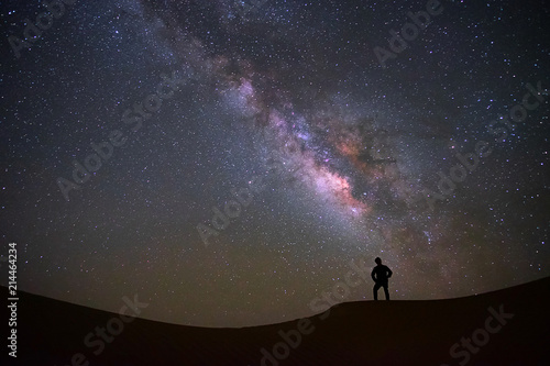 Milky way galaxy with a man standing and watching at Tar desert, Jaisalmer, India. Astro photography. © tanarch