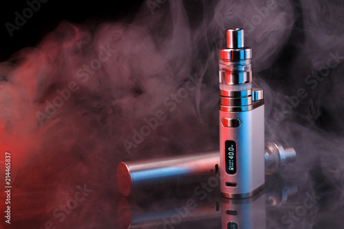 Electronic cigarette within vapor on black background. Toned light