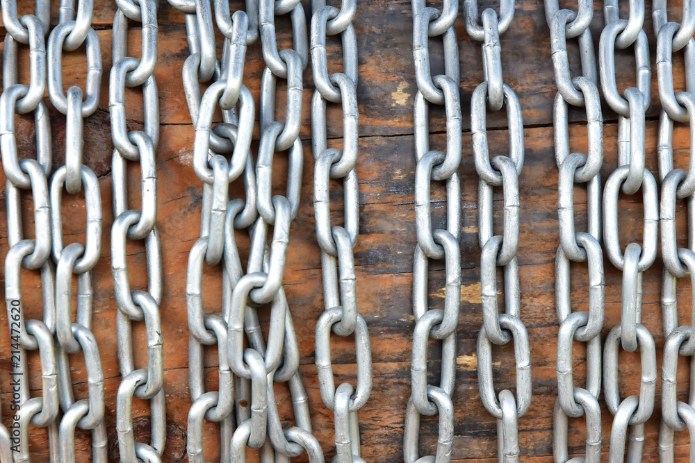 The chain is wound on a log, to raise a bucket of water from an old well. Close-up. The chain is wound on a log, to raise a bucket of water from an old well. Close-up.