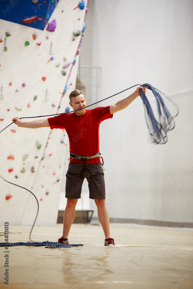 Photo of young man with protective cable during training session on climbing wall Photo of young man with protective cable during training session on climbing wall