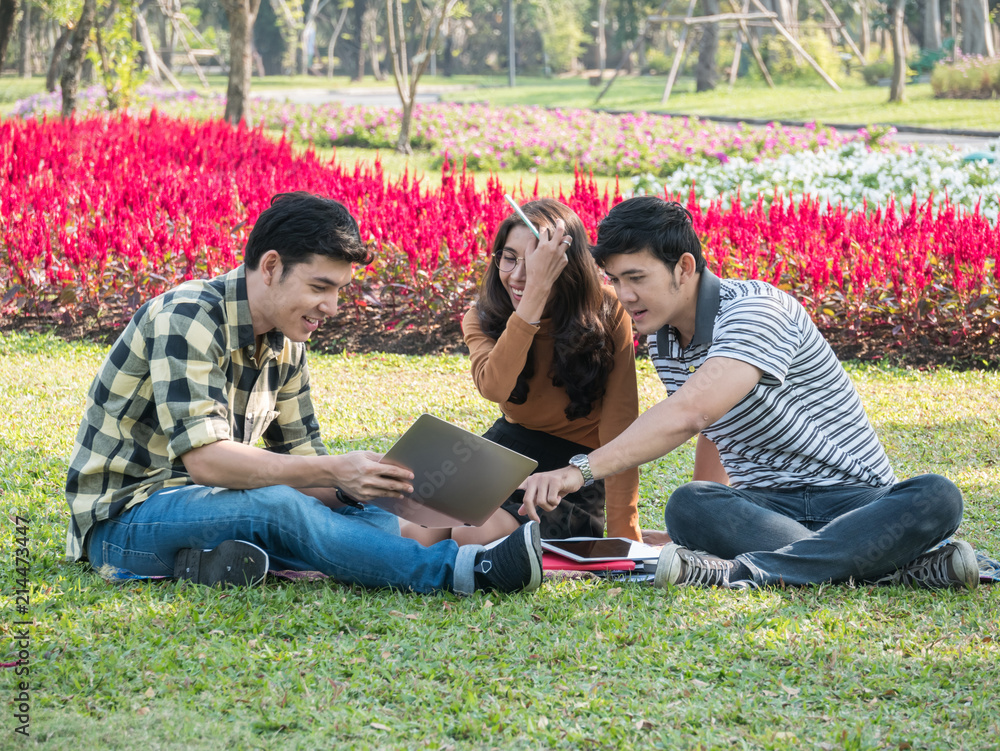 Group of college students with laptop and tablet computer while doing homework at park. Education concept. Group of college students with laptop and tablet computer while doing homework at park. Education concept.