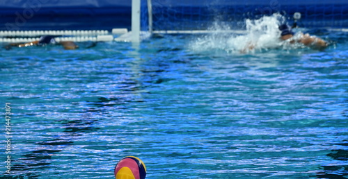 Waterpolo player swimming to the ball at the start. photo