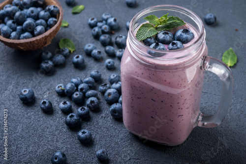  smoothie or shake with fresh blueberries and mint on a dark  background