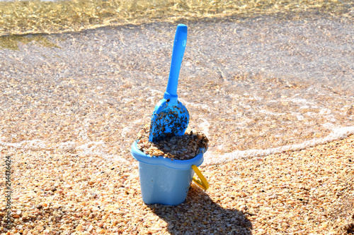 детское ведерко и лопатка оставлены на берегу моря