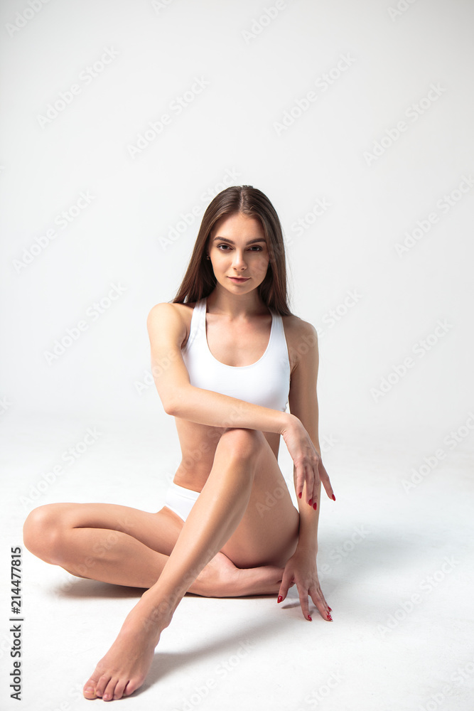 Young woman in a white sport costume, fitness model. Young woman in a white sport costume, fitness model.