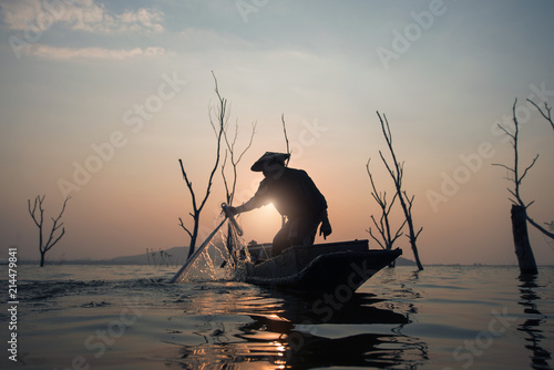 Fisherman is fishing in the lake during sunset in Thailand. © newroadboy