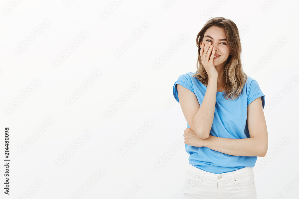 Girl cannot believe she has caring boyfriend. Happy carefree attractive woman in blue t-shirt, smiling broadly and holding palm on face, blushing, being pleased receiving great unexpected gift Girl cannot believe she has caring boyfriend. Happy carefree attractive woman in blue t-shirt, smiling broadly and holding palm on face, blushing, being pleased receiving great unexpected gift