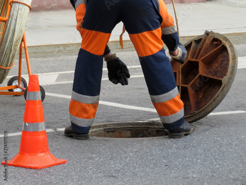 Картината върху платно Worker in uniform stand over the open sewer hatch