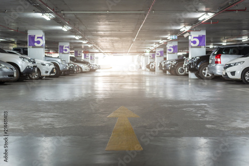 Blurred image of Underground parking with cars. White colors.