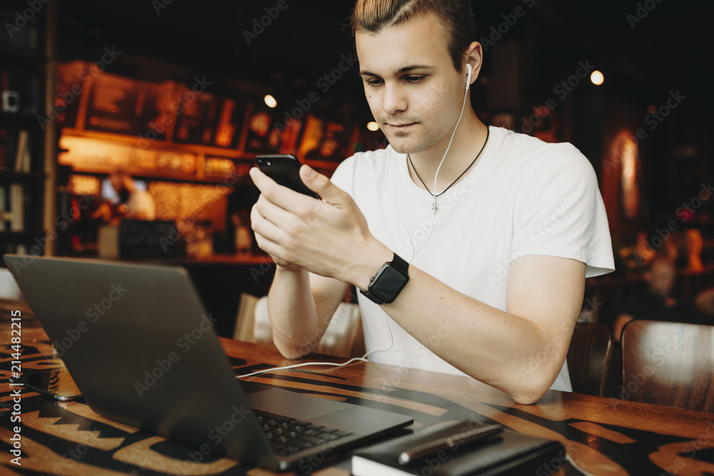 Young man in headphones using smartphone