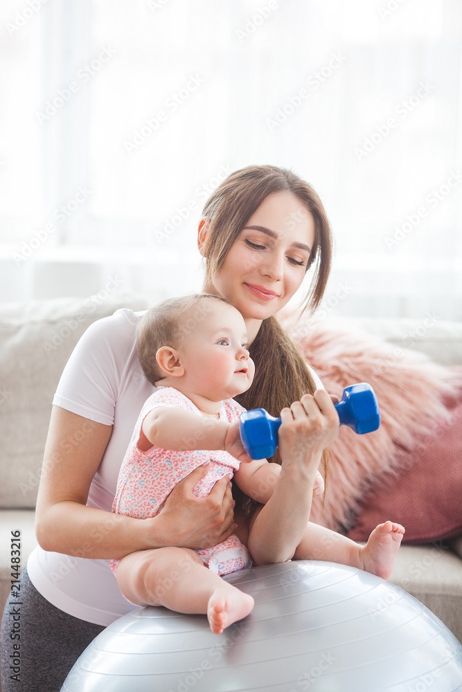 Young pretty mother working out with her little child at home Young pretty mother working out with her little child at home