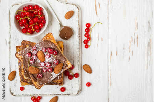 stack of fried toast with chocolate cream, red currant and almon photo