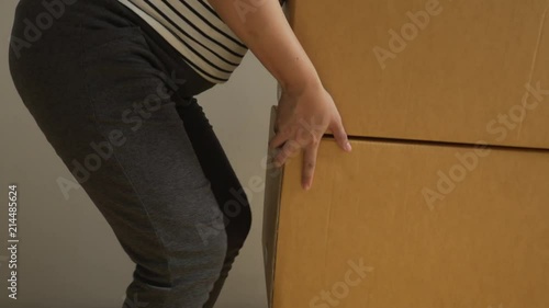 pregnant asian woman carry boxes for moving