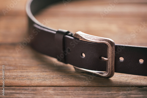 Leather belt on a wooden table photo