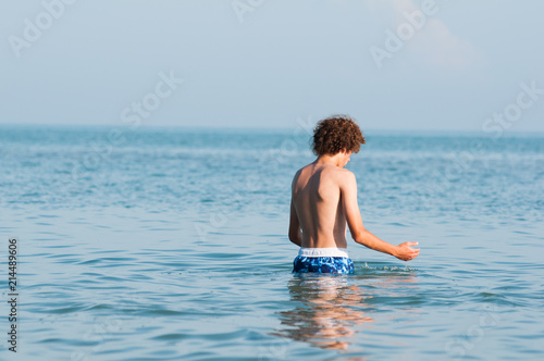 boy walking into Lake Erie to swim on a summer day