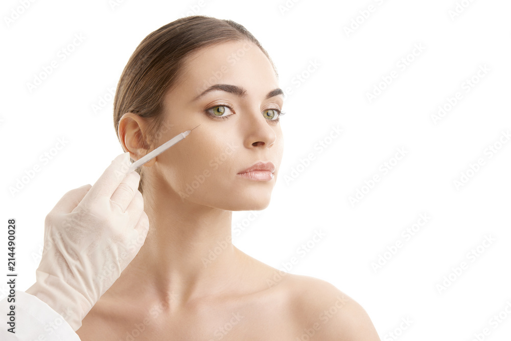 Woman at plastic surgery. Portrait of an attractive young woman receiving botox treatment. Isolated on white background. Woman at plastic surgery. Portrait of an attractive young woman receiving botox treatment. Isolated on white background.