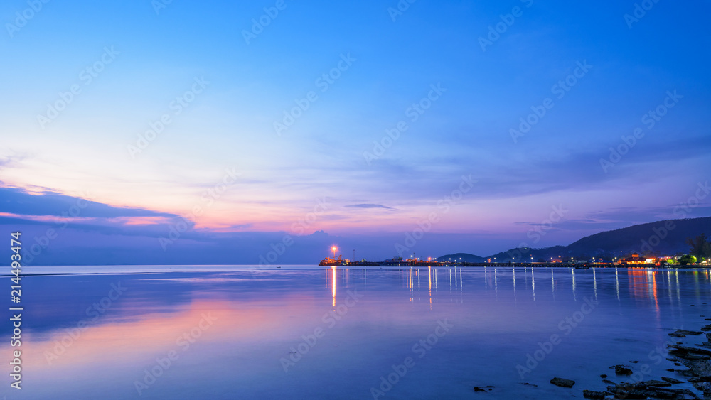 Beautiful natural landscape of the light reflecting the surface at Nathon Pier and boat on colorful sky twilight after sunset over the sea at Ko Samui island, Surat Thani, Thailand, 16:9 widescreen