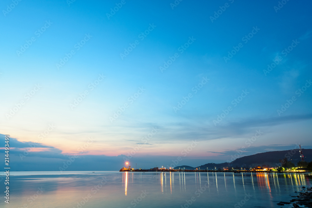 Beautiful natural landscape of the light reflecting the surface at Nathon Pier and boat on colorful sky twilight after sunset over the sea at Ko Samui island, Surat Thani, Thailand