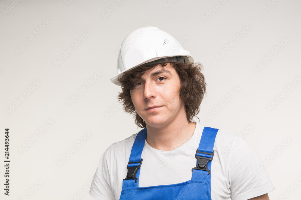 Construction, building and workers concept - Caucasian male builder wearing white helmet. Construction, building and workers concept - Caucasian male builder wearing white helmet.