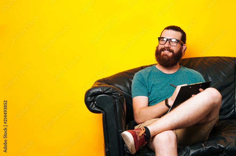 Happy bearded man writing something on paper Happy bearded man writing something on paper