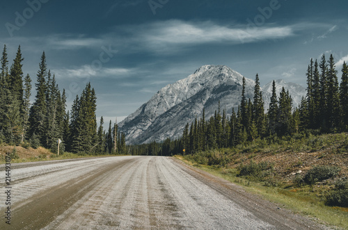 View of street highway with mountains and trees with blue sky and clouds. Banff National Park Canada Rocky Mountains.