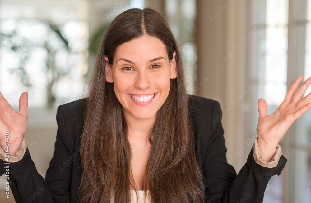 Young beautiful woman at home very happy and excited, winner expression celebrating victory screaming with big smile and raised hands Young beautiful woman at home very happy and excited, winner expression celebrating victory screaming with big smile and raised hands