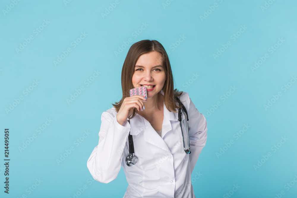 young female doctor tasting pack of pills young female doctor tasting pack of pills