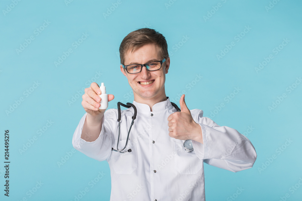 Young doctor in glasses recommending medical drops Young doctor in glasses recommending medical drops