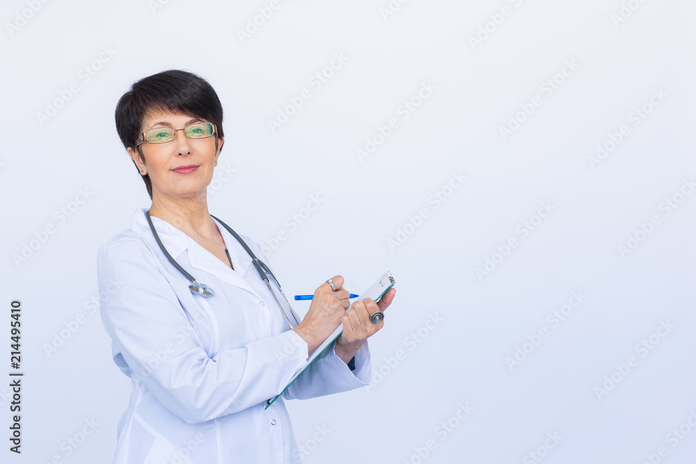 Portrait Of Female Doctor Writing On Clipboard Over a white background with copy space Portrait Of Female Doctor Writing On Clipboard Over a white background with copy space