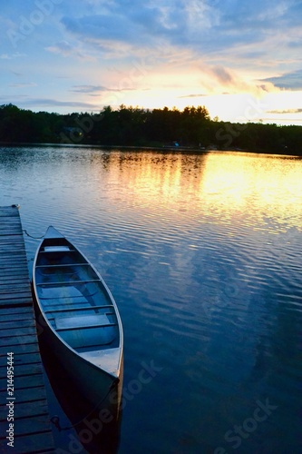 A sunset, a canoe, and a tranquil lake in Greenville, Michigan