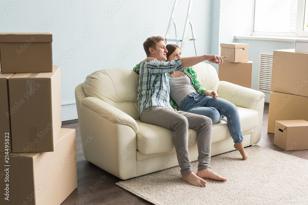 Just moved young couple on sofa planning interior in a new house. Just moved young couple on sofa planning interior in a new house.