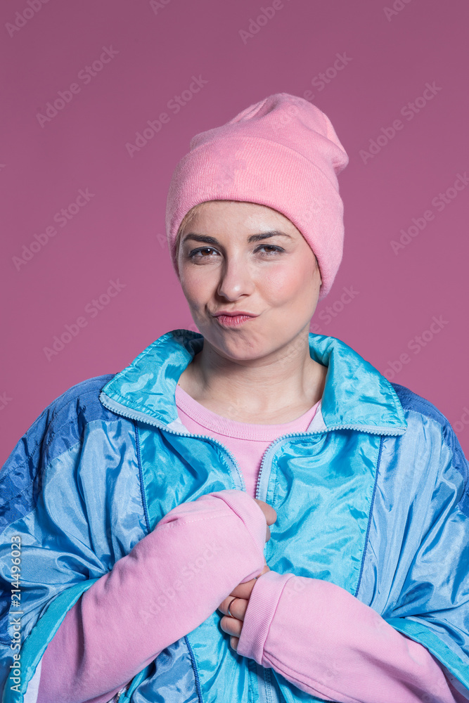 young woman doing facial expressions against a pink background young woman doing facial expressions against a pink background