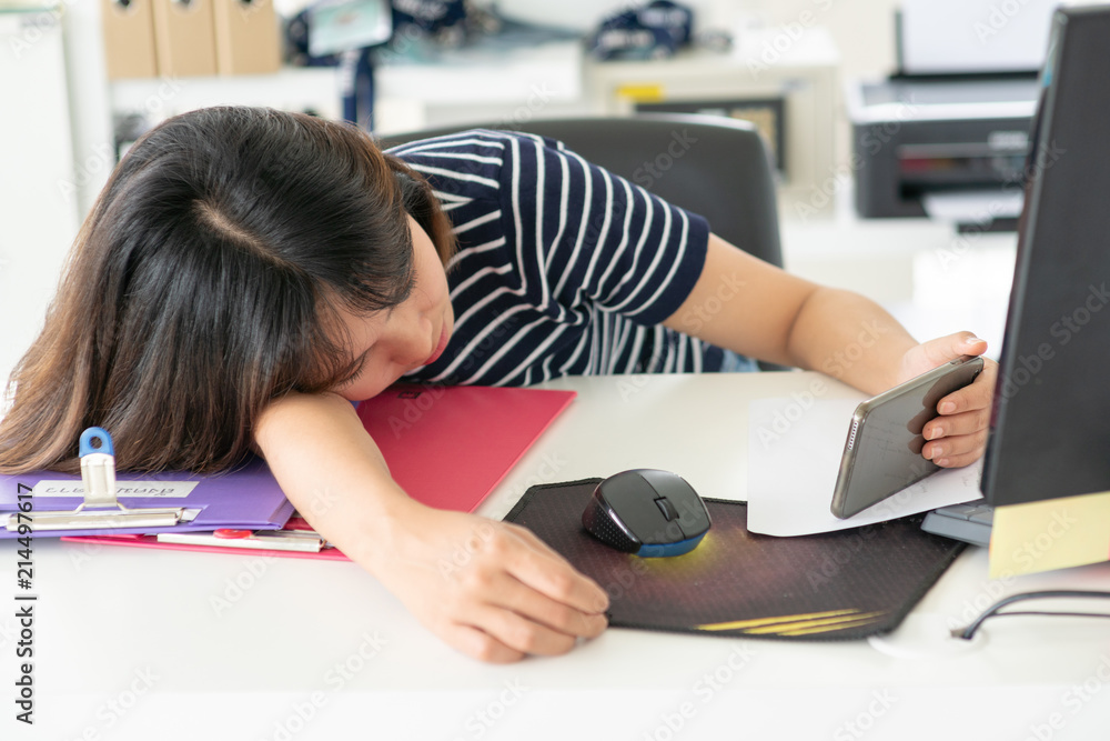 lazy working in office.Woman holding mobile phone and working on office desk.bored business workplace. lazy working in office.Woman holding mobile phone and working on office desk.bored business workplace.