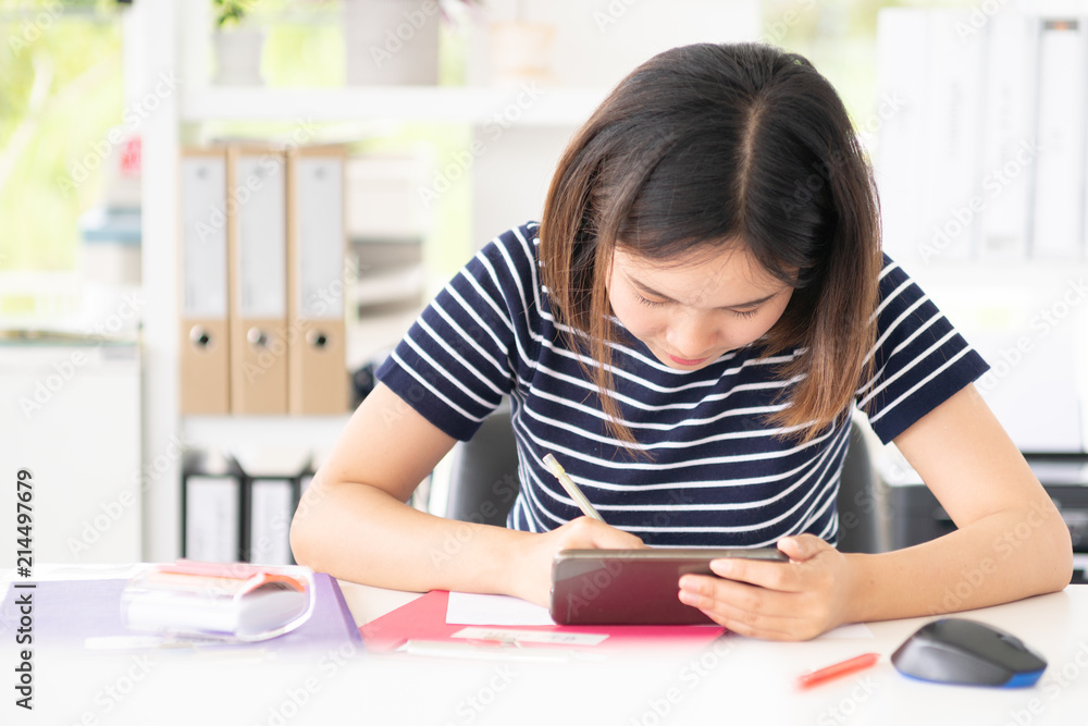 working in office.woman looking mobile phone and pen to note achievement. working in office.woman looking mobile phone and pen to note achievement.