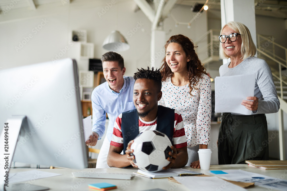 Group of happy intercultural fans expressing gladness while watching online broadcast of football championship Group of happy intercultural fans expressing gladness while watching online broadcast of football championship
