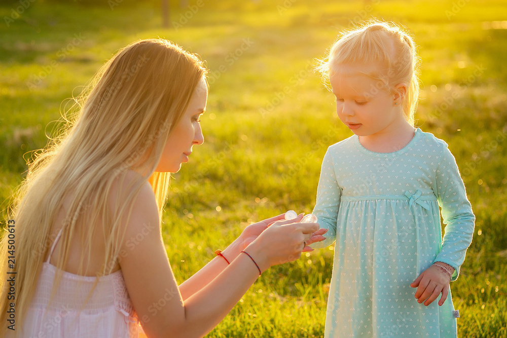 cute little blonde girl daughter in a blue dress with beautiful long ...