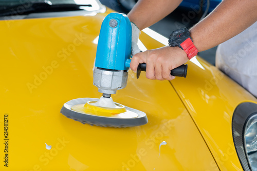 Car detailing series: Polishing yellow sports car hood © bhakpong
