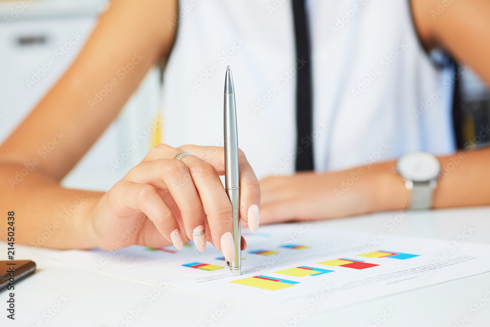 Female hand point silver pen to business graph on seminar. Bank credit, loan money, invest, tax situation review, income calculation form concept. Female hand point silver pen to business graph on seminar. Bank credit, loan money, invest, tax situation review, income calculation form concept.