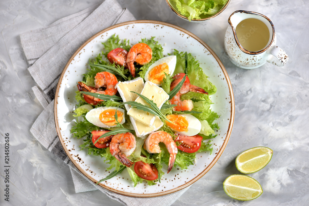 Healthy lettuce salad with arugula, large shrimps, cherry tomatoes, boiled egg, brie cheese and grated parmesan cheese. Healthy lettuce salad with arugula, large shrimps, cherry tomatoes, boiled egg, brie cheese and grated parmesan cheese.