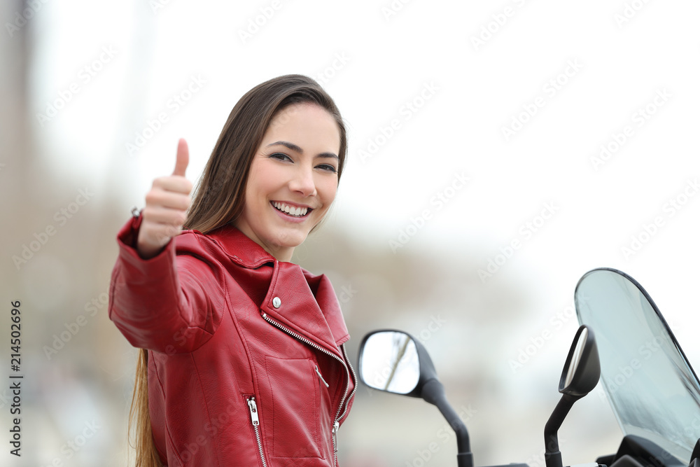 Fototapeta premium Motorcyclist looking at camera with thumb up outdoors