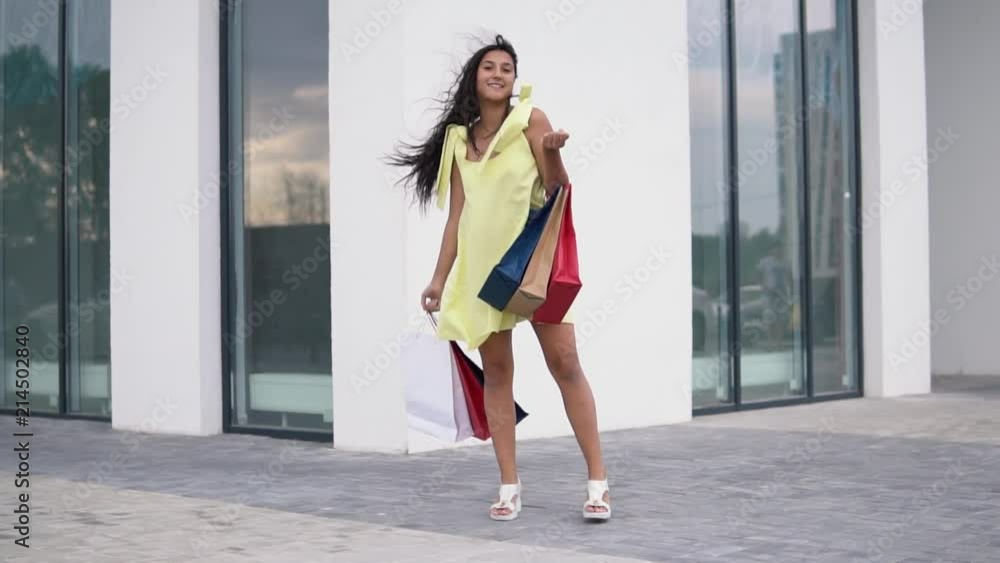 Beautiful model girl after shopping with packages in hands. slow motion. HD Beautiful model girl after shopping with packages in hands. slow motion. HD