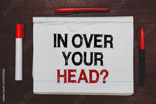 Handwriting text writing In Over Your Head question. Concept meaning To be involved in a difficult situation problem Written black, red words notepad on brown stage white highlighter red pens.