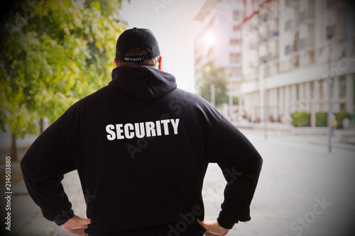 security man in a sunny day checking the city