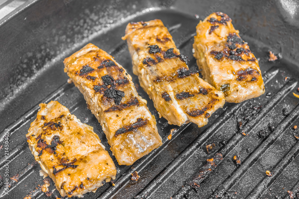 Slices of roasted salmon in a grill pan